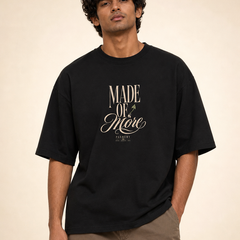 Male Indian model wearing PAXBURY Made of More black UC22 relaxed unisex T-shirt, front 'MADE OF More' original cream typographic print