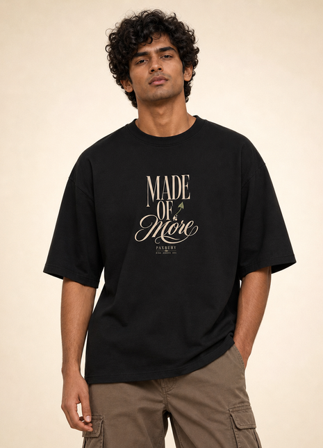 Male Indian model wearing PAXBURY Made of More black UC22 relaxed unisex T-shirt, front 'MADE OF More' original cream typographic print