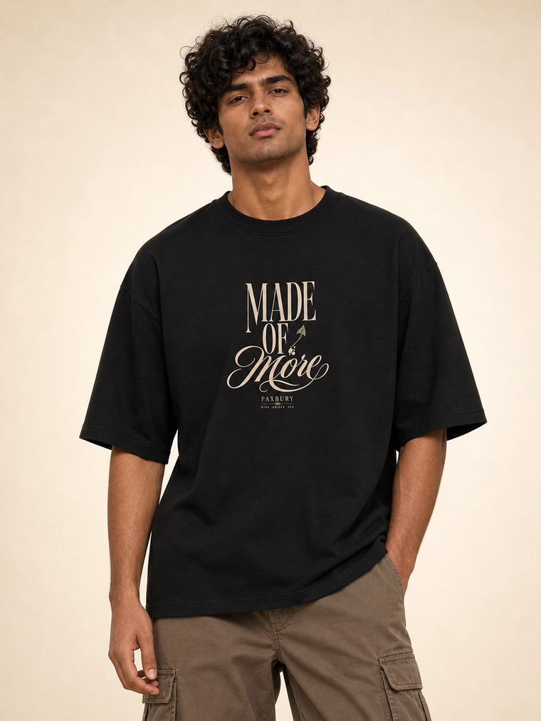 Male Indian model wearing PAXBURY Made of More black UC22 relaxed unisex T-shirt, front 'MADE OF More' original cream typographic print
