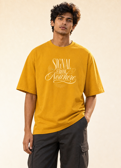 Indian male model standing wearing PAXBURY Signal From Nowhere Golden Yellow UC22 relaxed unisex oversized T-shirt with SIGNAL FROM Nowhere cream front lettering