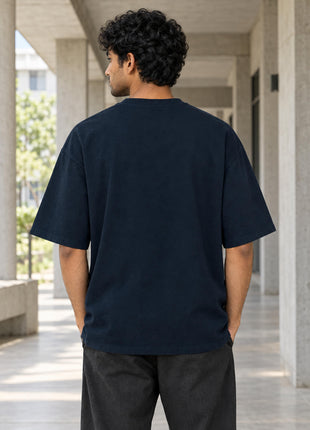Indian male model from behind showing unprinted navy back of Attendance 92% Attention 0% UC22 T-shirt