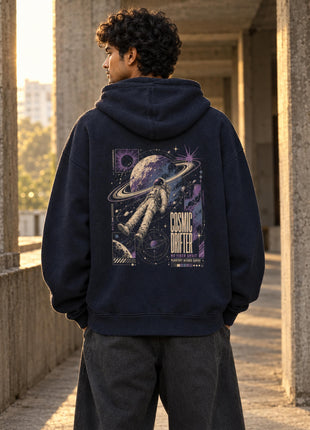 Indian male model wearing Cosmic Drifter navy oversized hoodie with ringed planet and floating astronaut back print