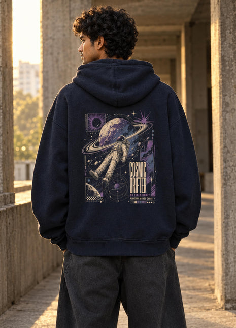Indian male model wearing Cosmic Drifter navy oversized hoodie with ringed planet and floating astronaut back print