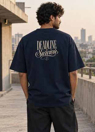 Indian male model showing cream elegant Deadline Survivors back print on navy oversized UC22 T-shirt
