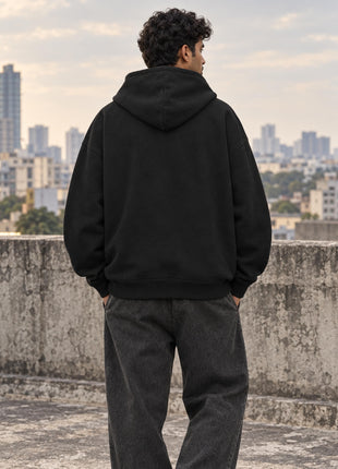 Plain back of black UH32 oversized hoodie on Indian male model, unprinted with relaxed hood