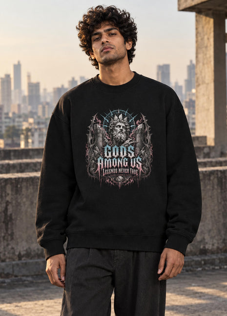Indian male model wearing Gods Among Us black oversized crewneck sweatshirt with illustrated crowned figure and statement front print