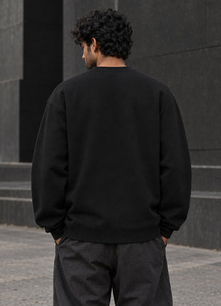 Indian male back view of Gods Among Us black oversized UH35 crewneck sweatshirt, plain unprinted back