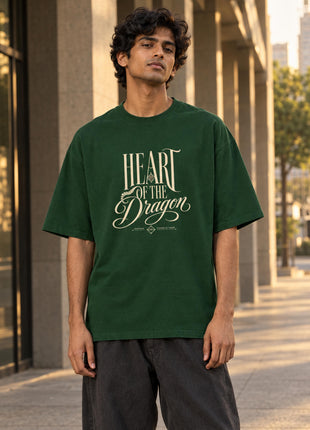 Indian male model wearing Heart of the Dragon bottle-green oversized T-shirt with cream HEART OF THE Dragon front lettering