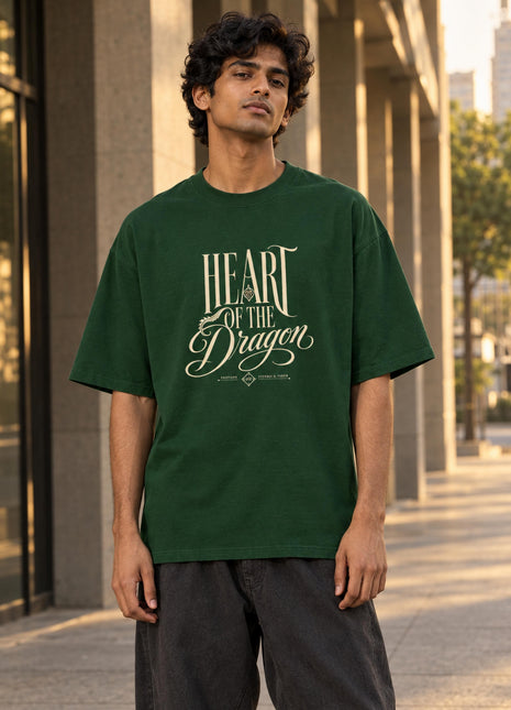 Indian male model wearing Heart of the Dragon bottle-green oversized T-shirt with cream HEART OF THE Dragon front lettering