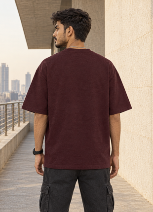 Kittl-created same Indian male model as front view, matching hair watch charcoal cargo pants and location; original plain back of PAXBURY Airplane Mode maroon T-shirt