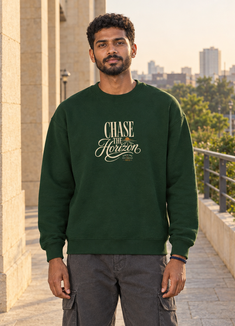 Kittl Indian male front model wearing PAXBURY Chase the Horizon bottle green UH35 oversized sweatshirt with compact cream typography