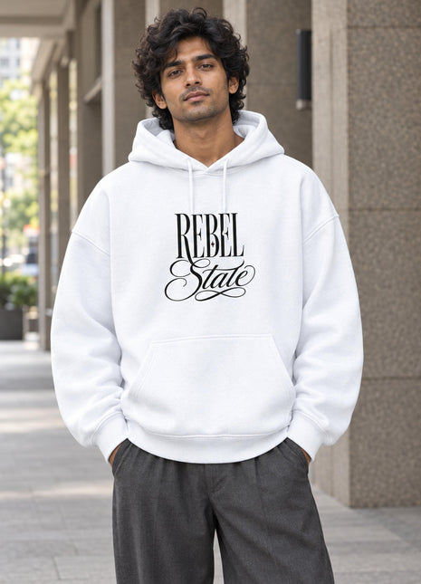 Indian male wearing Rebel State white oversized hoodie, elegant black REBEL State typographic front print