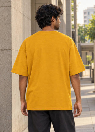 Indian male model wearing plain back of golden yellow Signal From Nowhere oversized cotton T-shirt