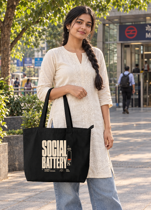 Social Battery black large tote reverse side — Indian woman standing beside urban metro entrance