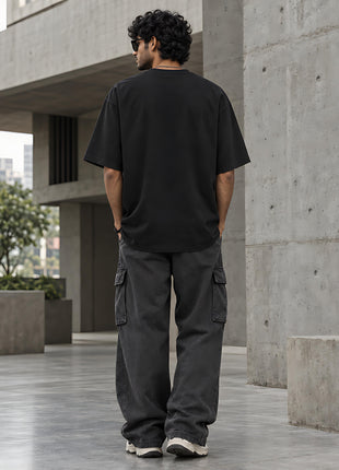 Indian male model back view of plain black oversized UC22 T-shirt with no rear print